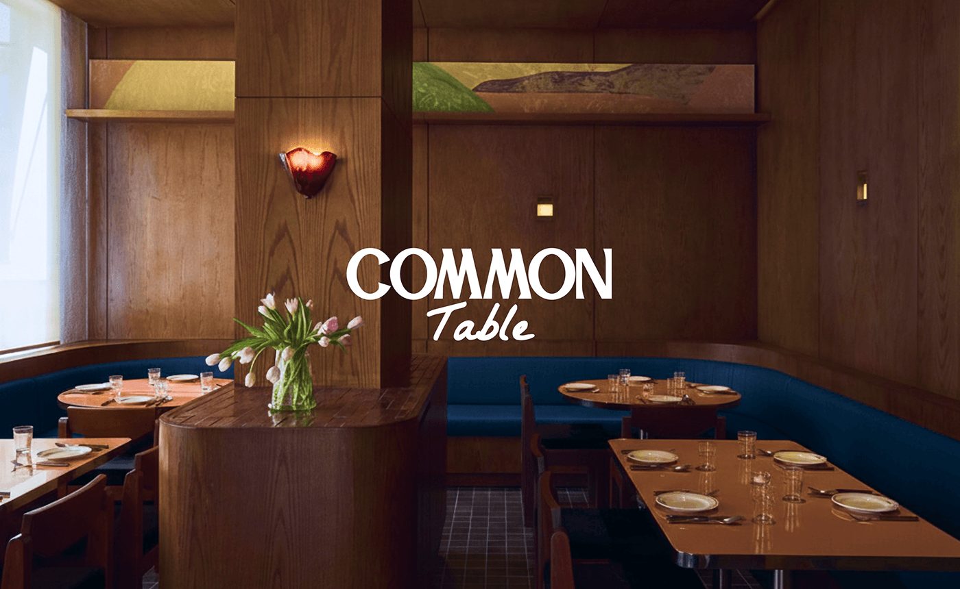 Common Table — 원목 벽 매장과 로고. 남색 벤치 소파가 브랜드 색을 공간으로 가져온다