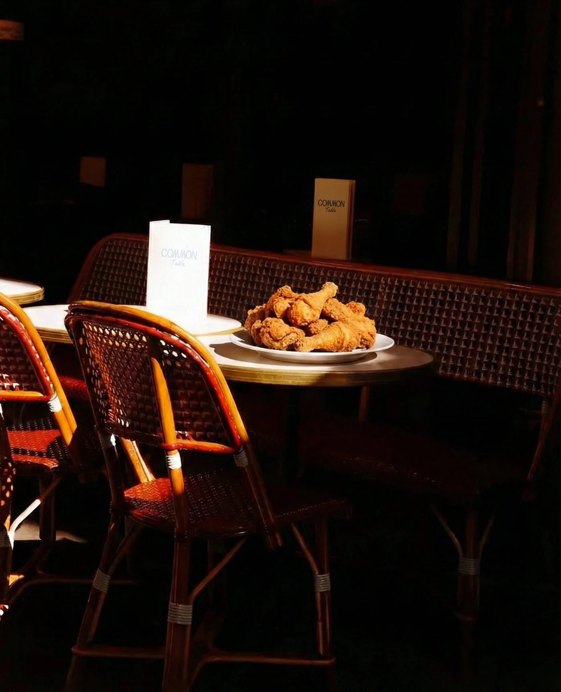 Common Table — 라탄 의자와 어두운 실내, 메뉴판에도 같은 로고
