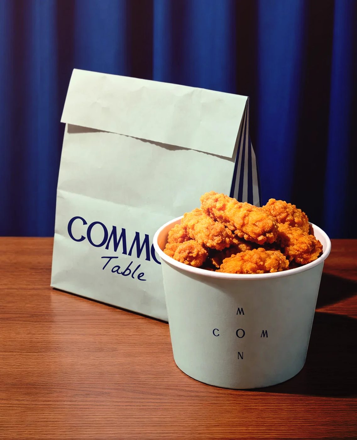 Common Table — 종이봉투와 치킨 버킷. 세이지 바탕에 남색 한 색