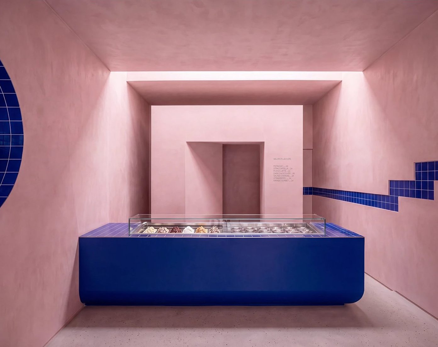 MELTO | Gelato — 파란 젤라토 카운터. 둥근 모서리 덩어리 하나, 뒤 벽은 액자처럼 파낸 분홍 문