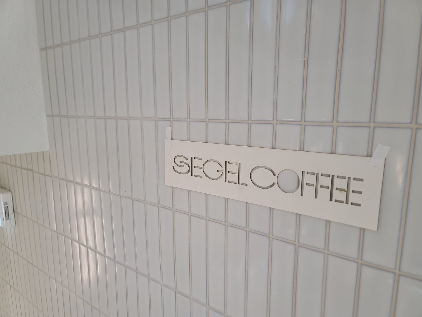 세젤커피 청담 시공 — 타일 벽 SEGEL COFFEE 로고